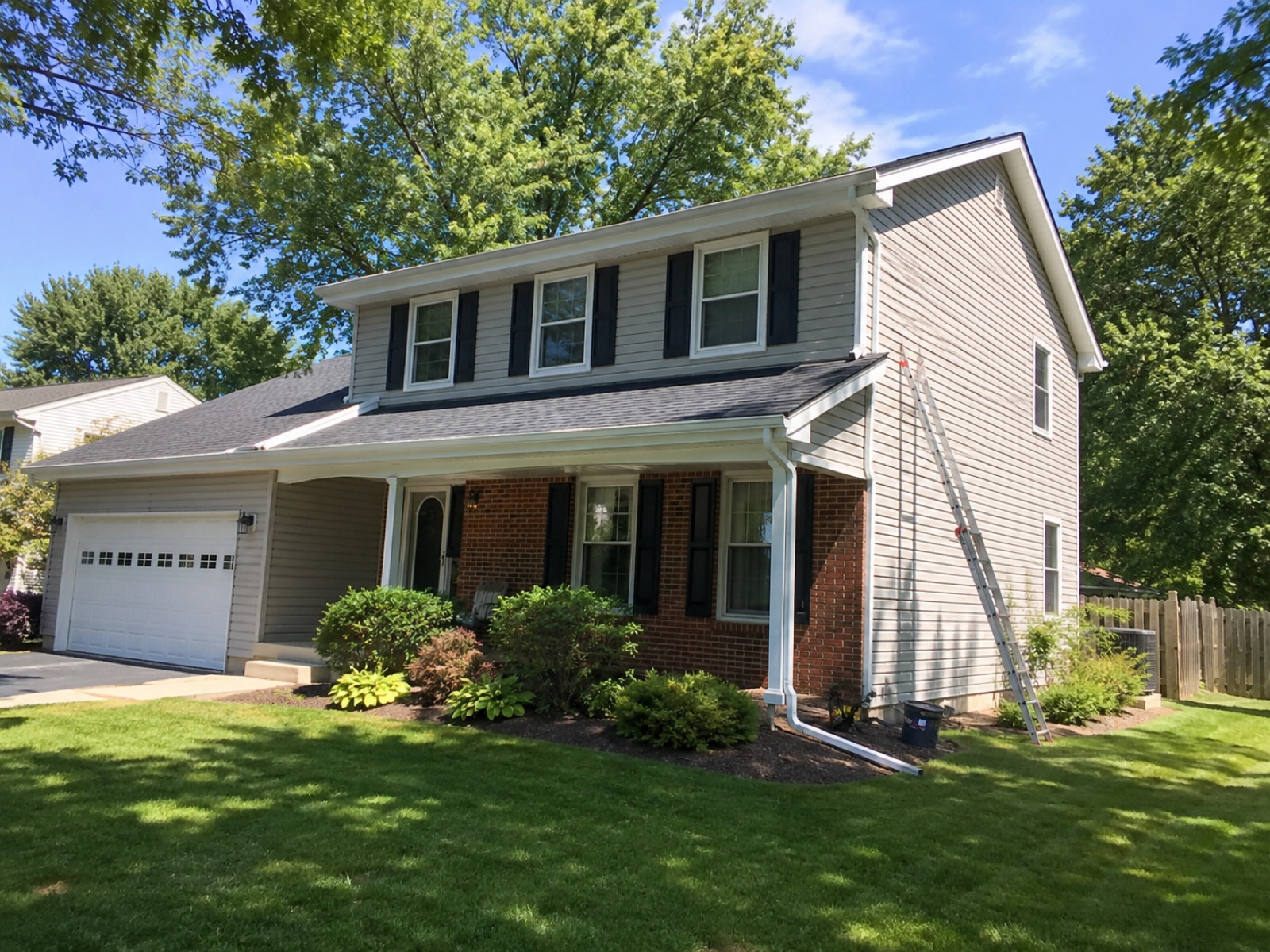 Ladder set against a clean roofline during a gutter cleaning