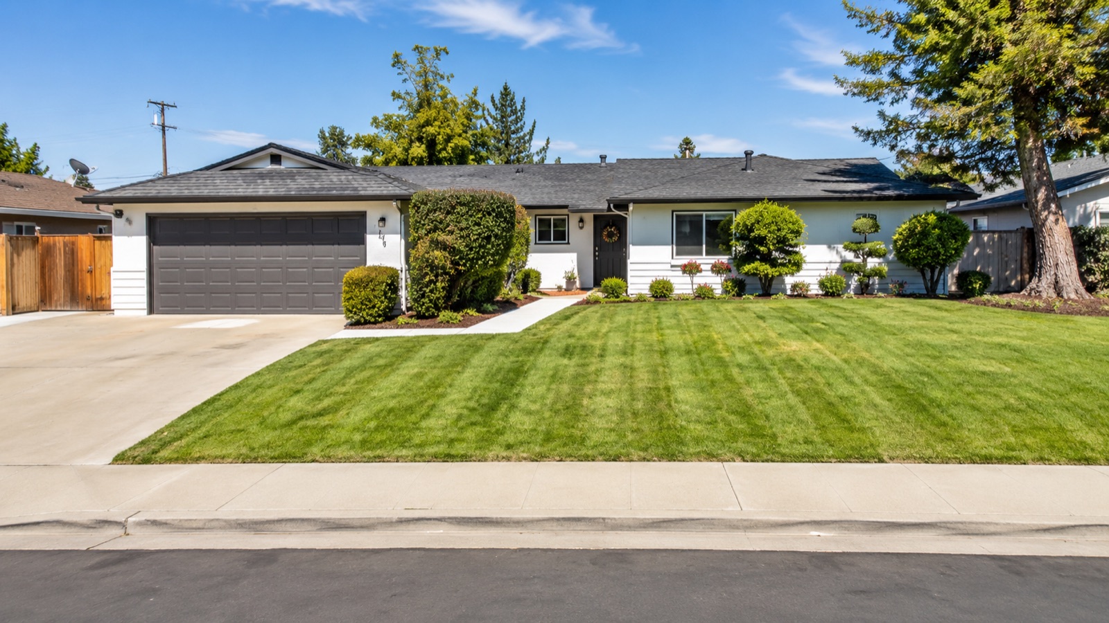 Freshly pressure-washed driveway and walkways fronting a manicured lawn